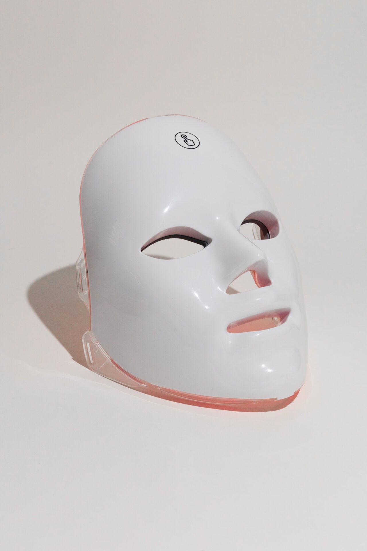 The GLOKORE Wireless LED Light Therapy Mask sits perfectly centered on a matte black background with a single spotlight above it — clean, dramatic, and evokes clarity in chaos.