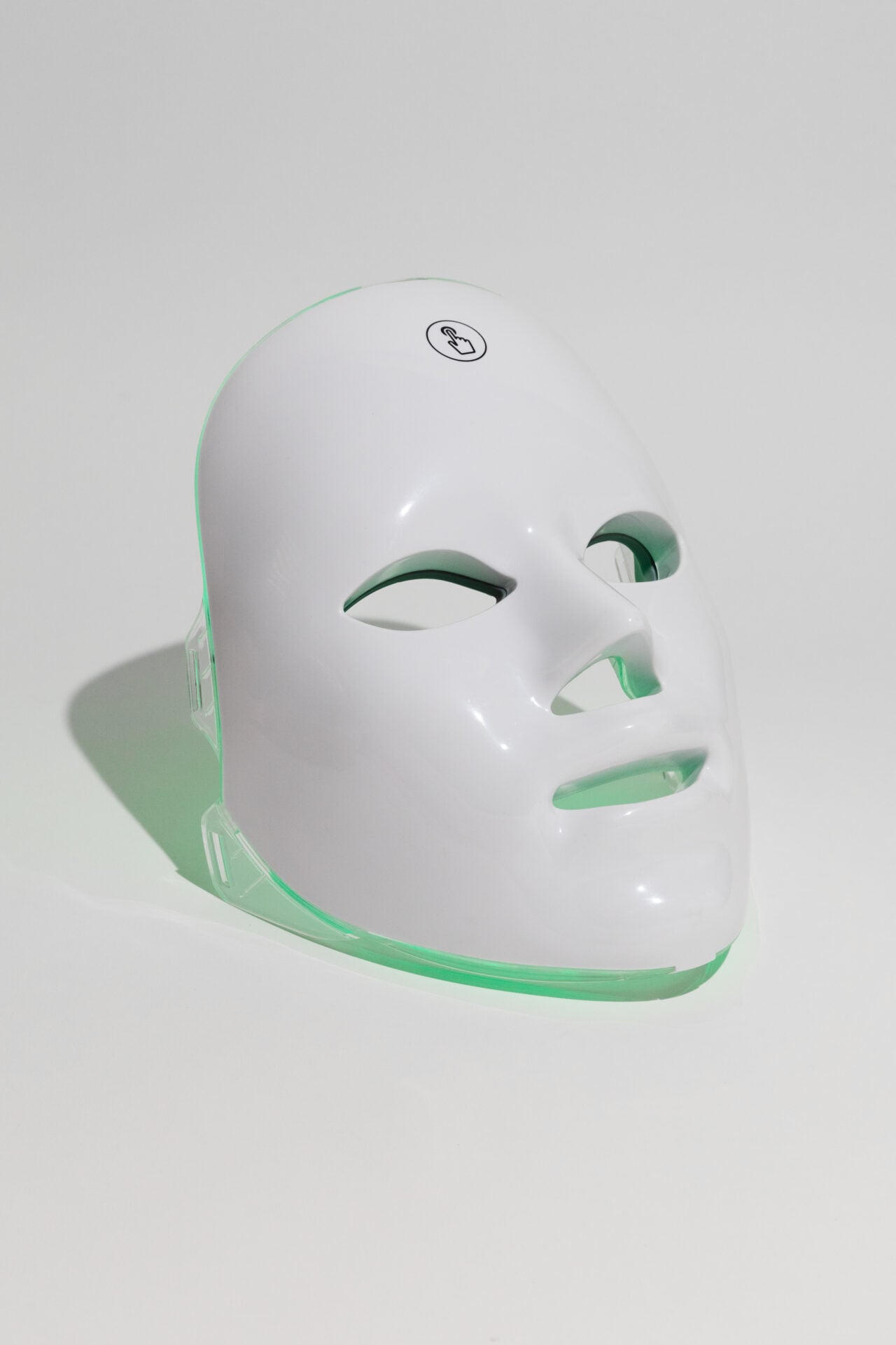 The GLOKORE Wireless LED Light Therapy Mask sits perfectly centered on a matte black background with a single spotlight above it — clean, dramatic, and evokes clarity in chaos.